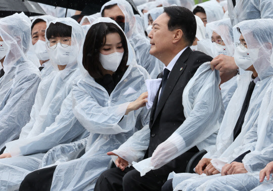 6일 오전 서울 동작구 국립서울현충원에서 열린 제67회 현충일 추념식에서 김건희 여사가 비에 젖은 윤석열 대통령의 옷을 닦아주고 있다. <연합뉴스>